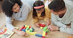 Education, building blocks and parents playing with their daughter on the floor in the living room. Happiness, smile and girl kid learning with toys with young mother and father in modern family home