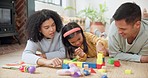 Building blocks, bonding and parents helping with their kid on the floor in the living room. Happy, smile and girl child learning with toys with young mother and father in their modern family home.