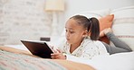 Digital tablet, relax and child on the bed playing an online game or watching a video on the internet. Technology, rest and young girl kid networking on social media or mobile app in bedroom at home.