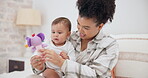 Mother, baby or child with a toy at home for development and growth. Cute toddler or infant kid playing with a woman or parent for love, care and security while learning mobility in a family bedroom