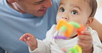 Father, baby or child with a toy in mouth for teething, development and growth in family home. Cute toddler or infant kid with a man or parent for love, care and security while playing and excited