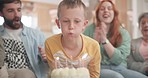 Child blowing, birthday party or happy family with cake clapping in fun celebration or house party with candles. Grandmother, grandfather or excited kid eating desert with dad, mom or grandparents 