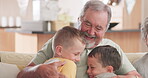 Family, love and grandchildren hugging their grandfather while sitting on a sofa in the living room of their home together. Smile, excited and kids embracing their senior male grandparent in a house