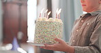 Boy, carrying and birthday cake for celebration with candles for family to make wish at house. Party, kid and burning candle with dessert with congratulation or fun at family home with happiness.