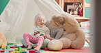 Cube, girl and siblings with laughing on floor for fun or education at family home with teddy bear. Happiness, kid and sisters are playing with toys for bond at house with stability for quality time.