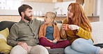 Conversation, relax and parents bonding with their kid on a sofa in the living room of their house. Communication, cup of coffee and girl child talking to her young mother and father in family home.