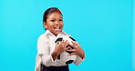 Children, catch and soccer ball with a student girl on a blue background in studio for playful fun. Kids, smile and a happy young female child with a football ready to enjoy a game of sports