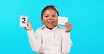 Face, learning math and girl with cards in studio isolated on a blue background. Education, multiplication and portrait of happy kid, student or child with paper to study mathematics for knowledge.