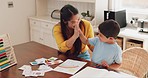 High five, teaching and mother doing homework with her child in the dining room of their family house. Learning, celebrate and young mom helping her boy kid with a mathematics school project at home.