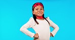 Superhero, strong and portrait of a girl child in a studio with a cape and face mask with wind blowing. Save, happy and kid model in cosplay outfit or costume isolated by blue background with mockup.