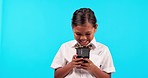 Mockup, child and girl with a smartphone, funny and social media against a blue studio background. Female kid, model and toddler with a cellphone, mobile app and laughing with connection and typing