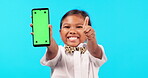 Little girl, phone and mockup screen with thumbs up for advertising or marketing against a blue studio background. Portrait of child with like emoji, yes sign or approval for smartphone advertisement