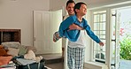 Father playing airplane with his child in the living room for bonding in their modern family house. Happy, smile and young dad carrying his boy kid while being playful together in the lounge at home.