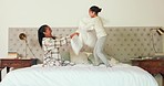 Happy, bedroom and mother tickling her child with love, care and playful expression at their home. Happiness, smile and young mom playing and bonding with her girl kid on a bed in their family house.