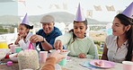 Happy, sweets and girl in park for birthday, celebration and party event outdoors for social gathering. Family, lunch and mother, grandfather and children at picnic with cake, presents and surprise