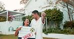 Property, keys and a homeowner couple with a sold sign in the garden of their new house together. Love, mortgage or real estate investment with a married man and woman in the yard for home ownership