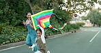 Family, flying a kite and girl with her mother outdoor together on the street for carefree or playful bonding. Kids, love and a woman running with her excited daughter while playing a game in summer