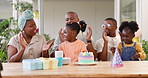 Birthday, children party and applause with a black family in celebration of a girl child in their home. Parents, grandparents and kids clapping while blowing candles on a cake at a milestone event