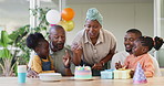 Black family, birthday cake and candles for children to celebrate with parents at a table. African woman, men and happy kids at home for a party, quality time and bonding or fun with love and care