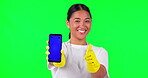 Asian woman, cleaner and phone in thumbs up on green screen for approval against a studio background. Portrait of female person or main show mobile smartphone with like emoji, yes or tracking markers