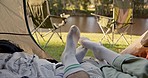 Camping, tent and feet of couple with love, romance and bond, rest and relax in a forest together. Legs, camper and touching foot in nature at a camp site, flirt and intimate while on break at a lake