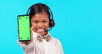 Technology, portrait of a girl with smartphone and headset against a blue background happy. Advertising or marketing, mockup space or connectivity and young female person with cellphone for branding