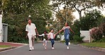 Family, parents and kids in street, skipping and playful with love, care or holding hands in neighborhood. Happy man, woman and children with funny walk, excited and playing outdoor in road in summer