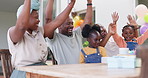 Black family, celebration and birthday of child at a table while clapping hands and singing. African woman, man and happy kids at home together for cake, quality time and bonding or fun at a party