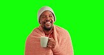 Man, coffee and blanket on a green screen for comfort, winter and warmth in a cup. Black person drinking tea with a smile and wrapped on a studio background to relax and cozy thinking of a warm drink