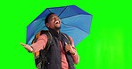 Rain, singing and black man with umbrella in green screen studio celebrating, happy or explore on mockup background. Freedom, celebration and African male hiking with sunshade, excited and having fun