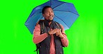 Rain, travel and black man with umbrella in green screen studio and hand on chest for gratitude while backpacking on mockup. Smile, blessed and thankful African guy hiking with sunshade in a storm 