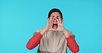 Shouting, announcement and alert with a woman on a blue background in studio for attention or warning. Portrait, screaming and hands over mouth with a young female person yelling a loud message