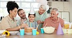 Kids birthday cake, candles and happy family celebrate in excited love, care and fun together in home. Happiness, grandparents and parents at party for boy with smile, celebration and congratulations