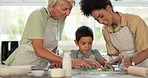Mother, grandmother and a child baking and learning with fun in a kitchen at home for development. Mixed race women and boy kid helping or teaching cookie shape for quality time activity and play