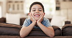 Happy, cute and face of a child on the sofa for playing, relax and weekend fun. Smile, youth and portrait of a little boy kid with an adorable expression, charming and on vacation on the couch