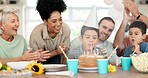 Birthday party, child blowing candles and happy family celebrate with applause, singing and sweets together in home. Happiness, kids celebration and congratulations, people at excited event with cake