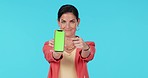 Green screen smartphone, pointing or happy woman gesture at mockup logo design, branding and advertising space. Studio portrait, phone UI interface or person with online commercial on blue background