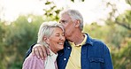 Kiss, face and senior couple in nature, having fun and bonding together. Portrait, romance and happy elderly man and woman with funny laugh, smile and enjoy quality time outdoor on vacation for love.