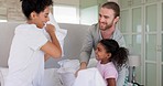 Pillow fight, happy parents and kid play in bedroom with energy, funny games and joke together at home. Excited mom, dad and girl child laughing with pillows, crazy morning and interracial family