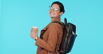 Travel, coffee and backpack with a woman tourist in studio on blue background for sightseeing or adventure. Portrait, smile and glasses with a happy young female person drinking a beverage on holiday