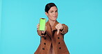 Green screen phone, thumbs down and woman point at bad mockup design, brand fail and disagreement on studio space. Mobile logo, no vote and portrait person with negative opinion on blue background