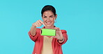 Green screen phone, face and happy woman point at mock up promotion, brand presentation and mobile application. Portrait, smartphone connection and person gesture at online service on blue background