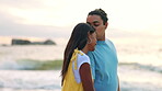 Love, kiss and a couple walking on the beach together for romance on their anniversary or honeymoon day. Travel, valentines day or vacation with a young man and woman bonding by the ocean in nature