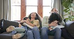 Family, hug and parents with children on a sofa happy, excited and playing in their home. Love, embrace and kids on a couch with mother and father, bonding and enjoying the weekend in a living room