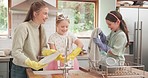 Mother, girl kids and cleaning dishes in home kitchen for hygiene, germs or dirt with teamwork. Mama, children and cloth for washing, drying and learning together for skills in gloves, chat and laugh