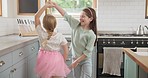 Energy, dance and children friends in the kitchen spinning, playing and bonding in modern home. Happy, playful and young girl kids dancing and having fun together to music, playlist or album in house