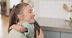 Mom, love and hug girl with a smile or bonding, support and care for child with happiness in home, house or kitchen. Hugging, mother and daughter with happy embrace and quality time together