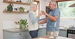 Dance, love and romance with a senior couple in the kitchen of their home together for bonding in retirement. Music, smile or funny with a happy elderly man and woman sharing a moment in the house