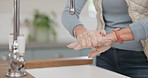 Soap, water and a woman washing her hands in the kitchen of her home for hygiene or hydration. Health, cleaning and skincare with a senior female person at the tap to remove bacteria from her skin