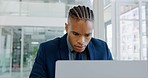 Computer, working and businessman in the office doing research online for a corporate legal project. Technology, professional and young African male lawyer planning a case on a pc in modern workplace